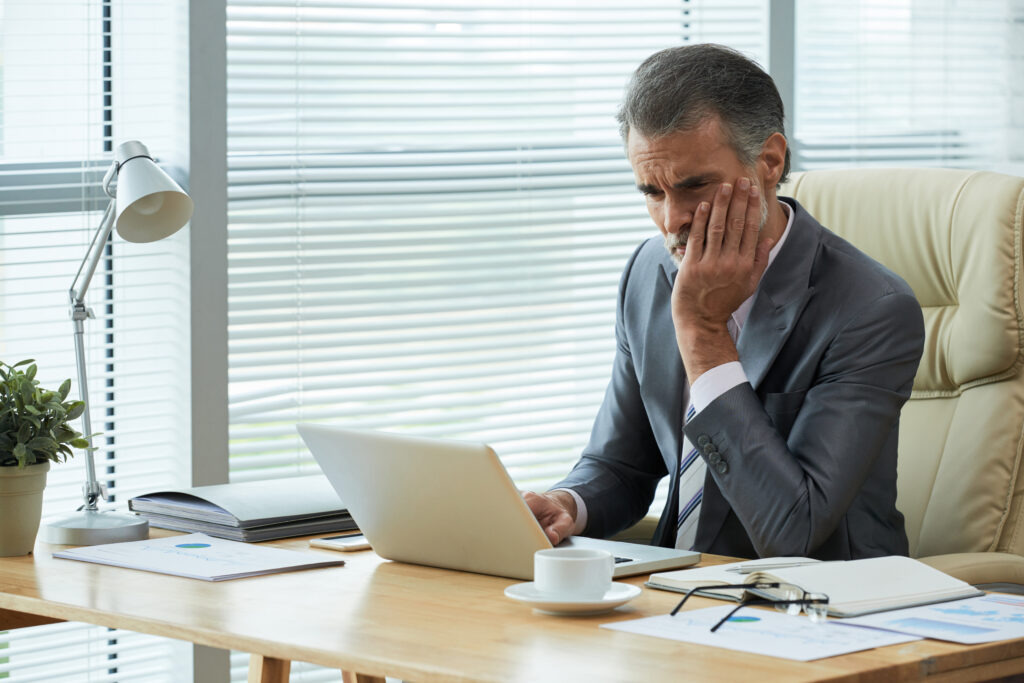 portrait middle aged entrepreneur finding out about bankrupcy with frustrated gesture